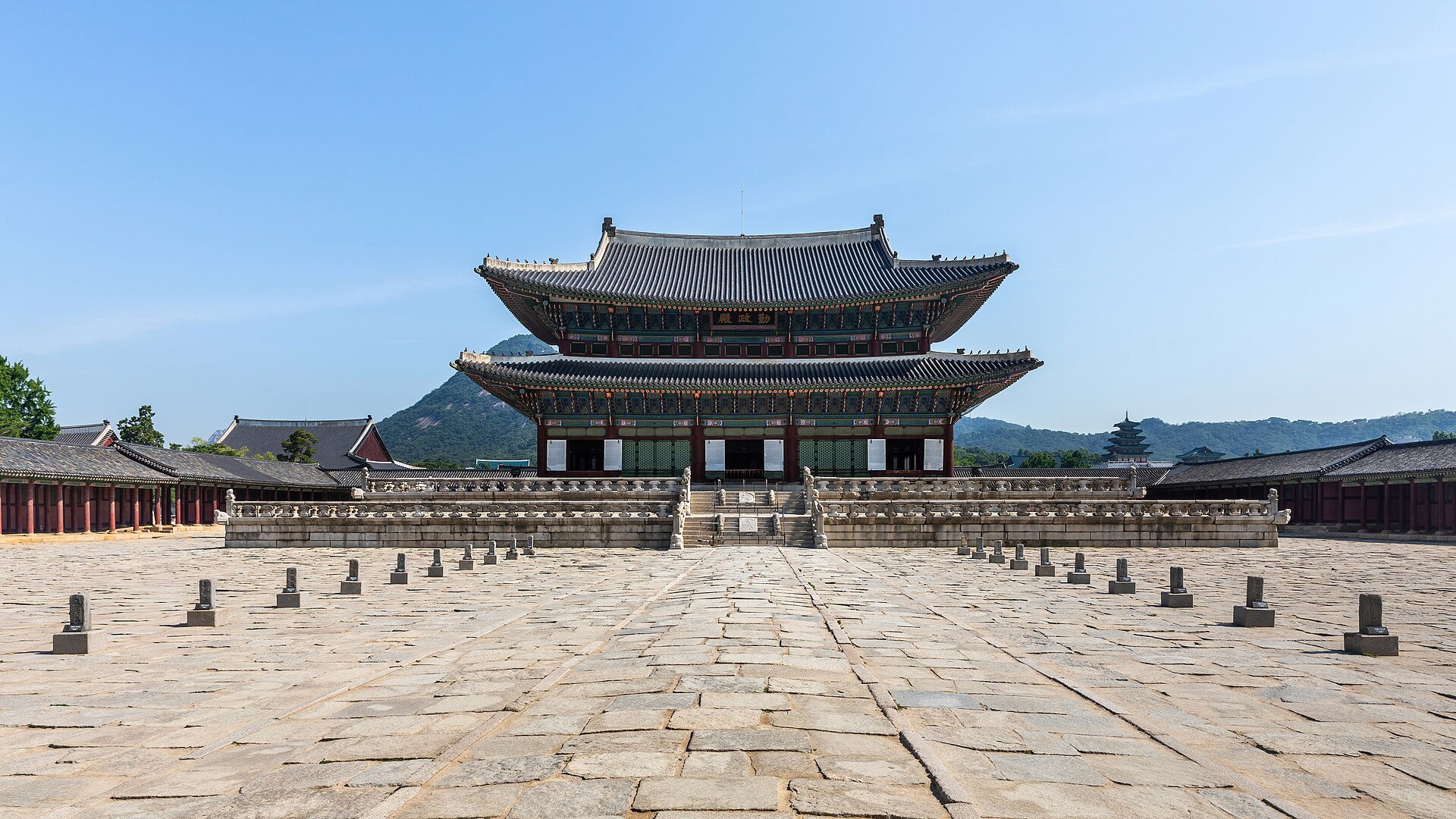 景福宫勤政殿正面全景，重檐庑殿顶与丹青彩绘门廊，蓝天映衬下的朝鲜王朝正殿